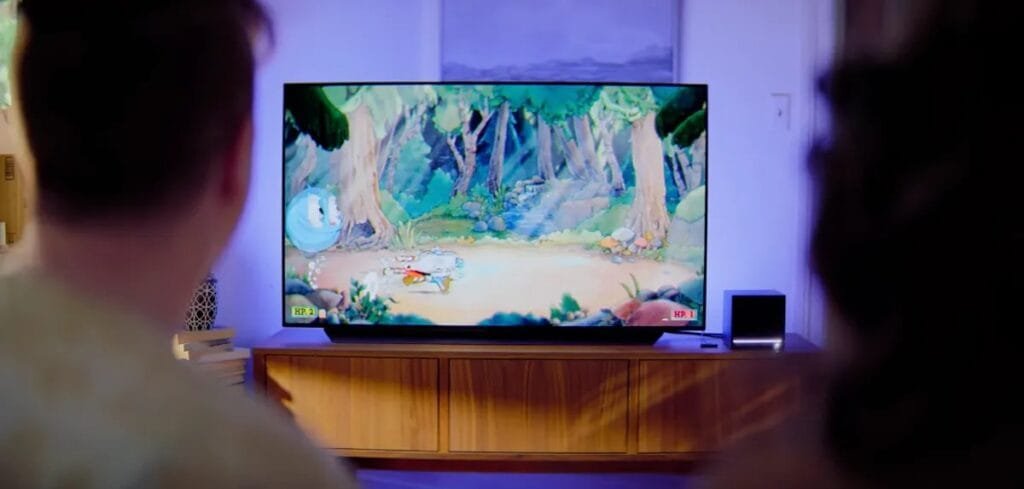 Pessoa jogando jogo em estilo cartoon na TV da sala com Steam Machine conectada